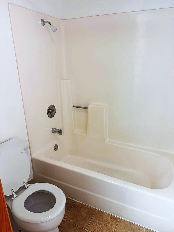 Spotless white bathtub and shower surround after a deep clean