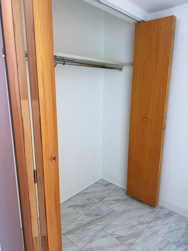 Clean empty closet with bifold doors and wiped shelving