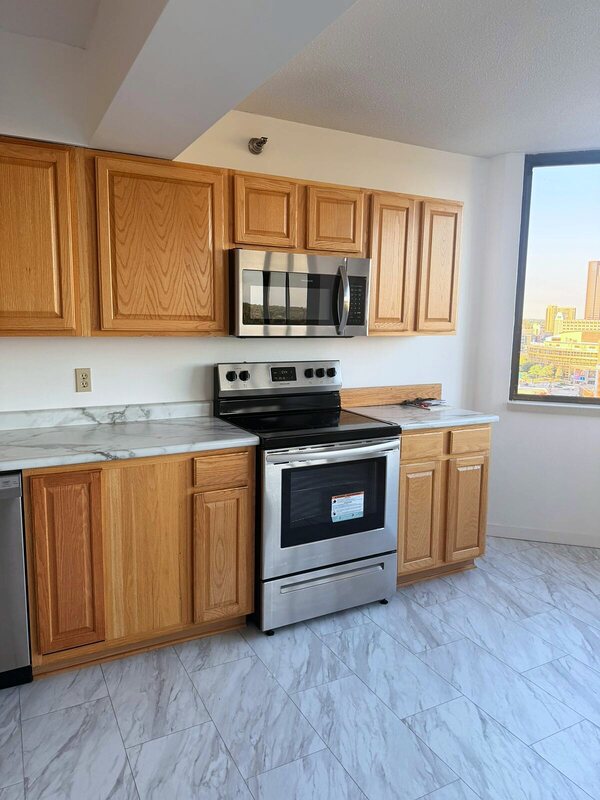 Clean stainless range and over-range microwave beside a window overlooking St. Paul