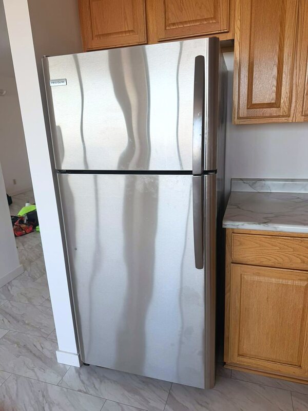 Polished stainless refrigerator in a cleaned apartment kitchen