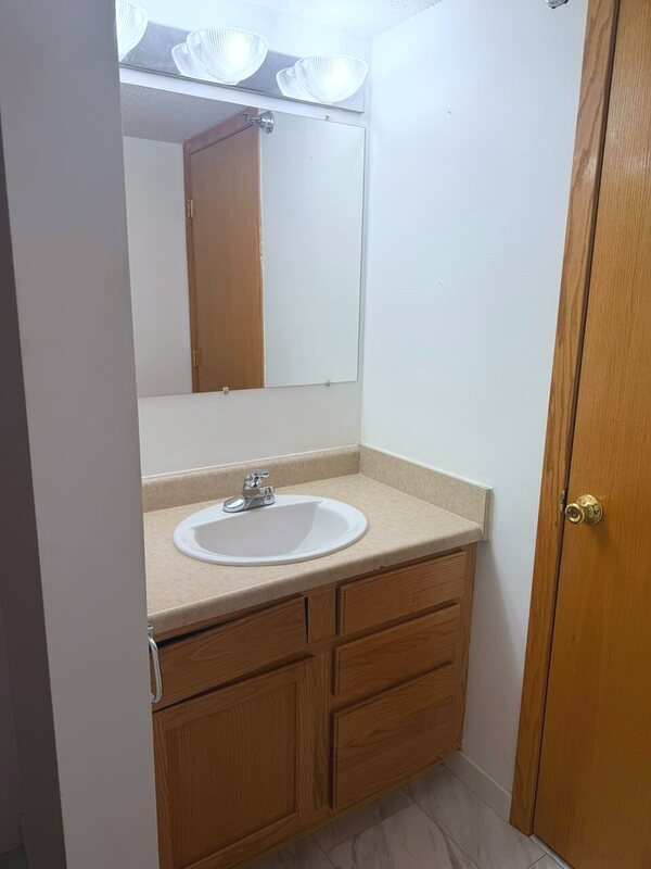 Clean oak vanity with mirror in a second bathroom